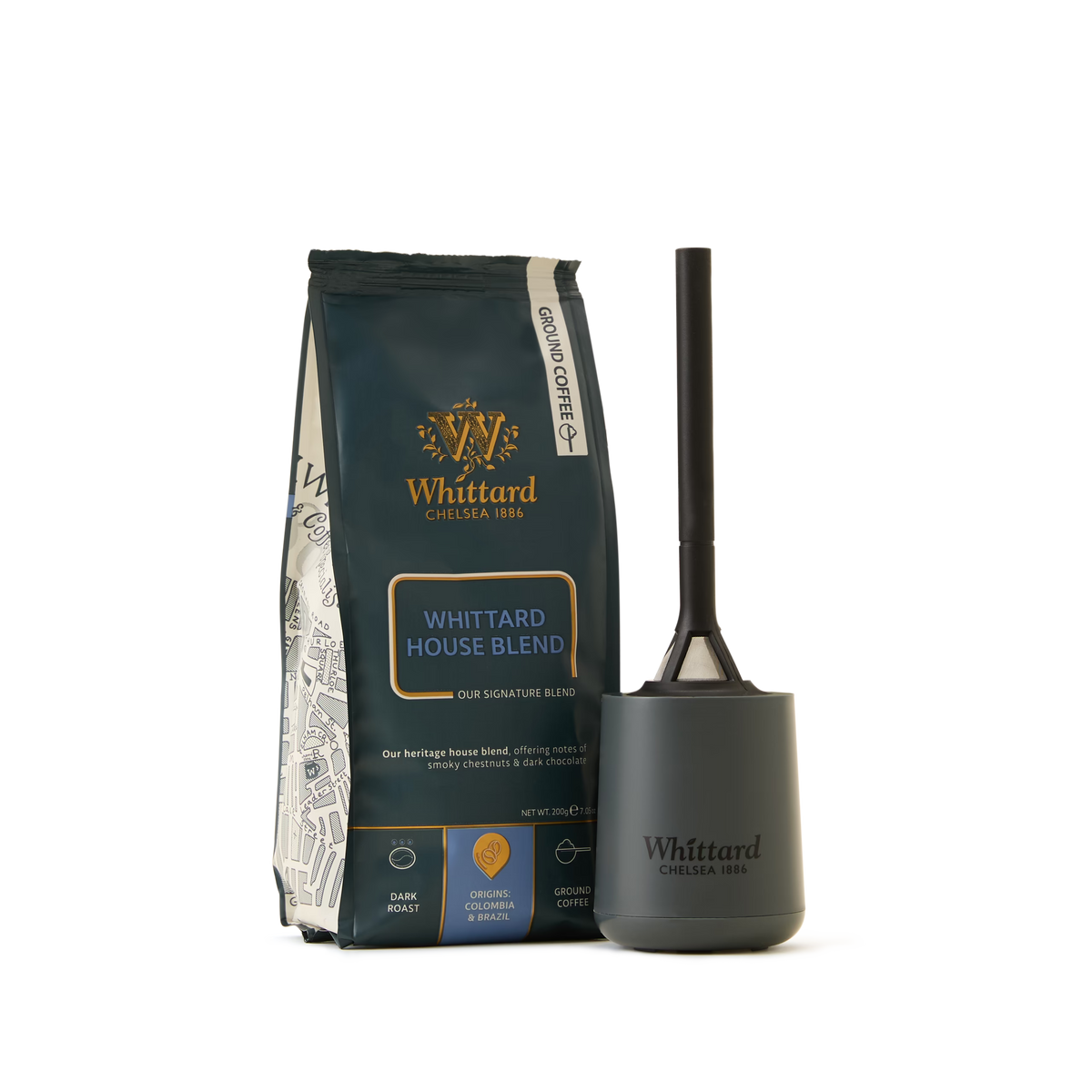 A Coffee Lovers Kit featuring Whittard House Blend ground coffee stands next to a dark, handled container—both labeled Whittard. The set showcases the House Blend’s dark colors, gold accents, and blend details that emphasize its status as a speciality coffee. The background is white.