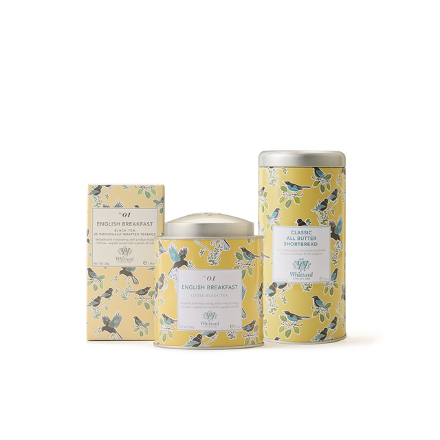 Three yellow floral-patterned containers—a rectangular English Breakfast tea box, a round loose leaf tin, and a tall Classic All Butter Shortbread tin—make up The English Breakfast Collection, a delightful set that’s perfect as a British tea gift. Displayed against a crisp white background, this elegant collection embodies the timeless charm of traditional English Breakfast tea.