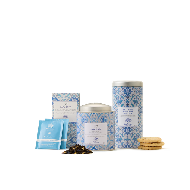 The Earl Grey Collection—featuring blue floral-patterned tea tins, Earl Grey tea bags, loose leaf tea, and a tempting stack of cookies—is arranged against a white background, making it perfect for an indulgent afternoon tea or as an elegant gift set.