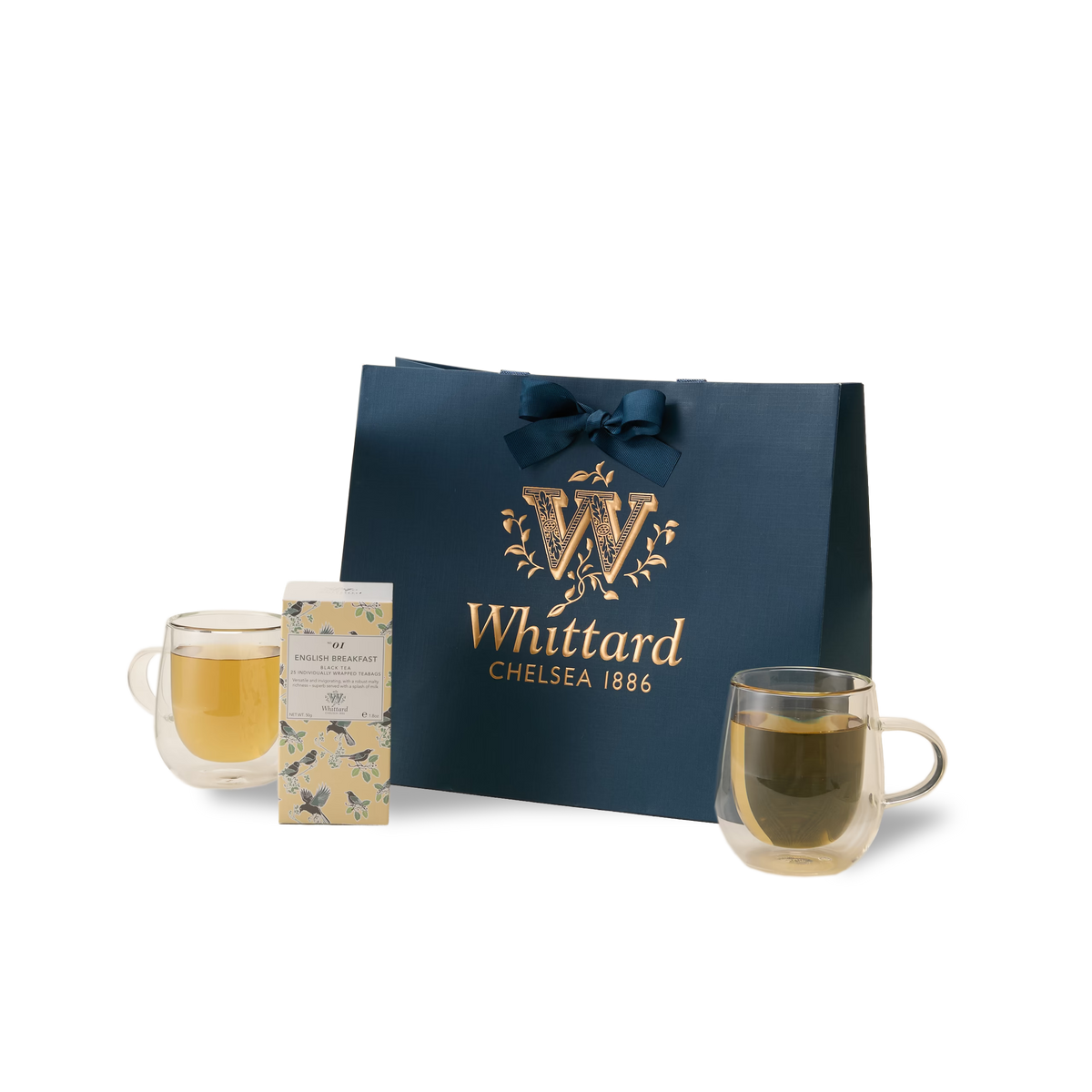 The Everyday Tea Gift Set, featuring two double-walled glass mugs filled with tea, a box of Whittard English Breakfast individually wrapped teabags, and a dark blue Whittard Chelsea 1886 gift bag adorned with gold lettering and a ribbon—all beautifully arranged against a white background—makes the perfect tea gift for any occasion.