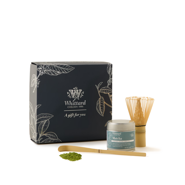 Matcha Must-Have Collection featuring a black gift box, bamboo matcha whisk, tin of matcha green tea, bamboo scoop, and a sample of matcha powder, all displayed on a white background.