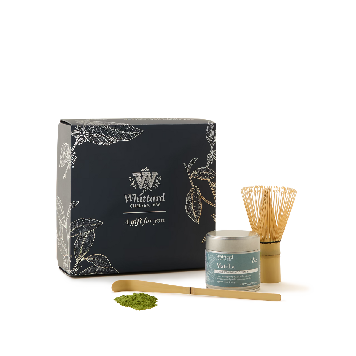 Matcha Must-Have Collection featuring a black gift box, bamboo matcha whisk, tin of matcha green tea, bamboo scoop, and a sample of matcha powder, all displayed on a white background.