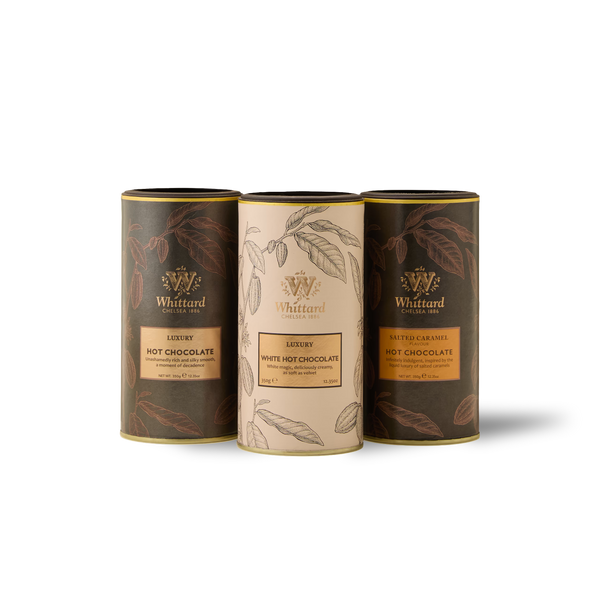 Three cylindrical Whittard hot chocolate tins—Luxury Hot Chocolate, White Hot Chocolate, and Salted Caramel Hot Chocolate—are arranged side by side on a white background, beautifully presenting The Hot Chocolate Classics Subscription as the perfect trio for an indulgent treat or a delightful addition to any hot chocolate routine.