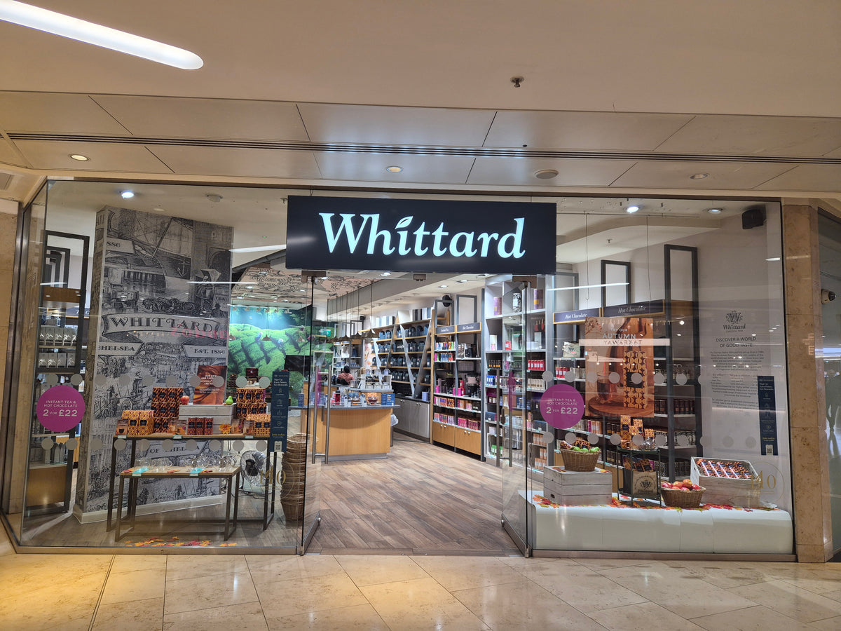 The storefront of the Whittard Book & Gift Shop in a shopping mall, featuring a prominent black sign with white 'Whittard' branding above glass doors.
