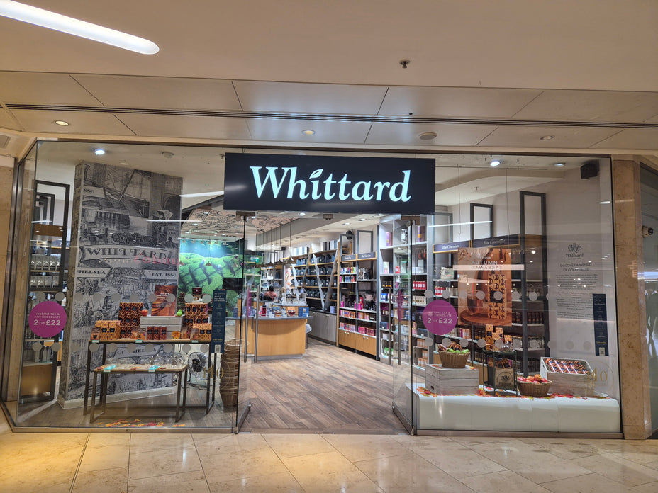 The storefront of the Whittard Book & Gift Shop in a shopping mall, featuring a prominent black sign with white 'Whittard' branding above glass doors.