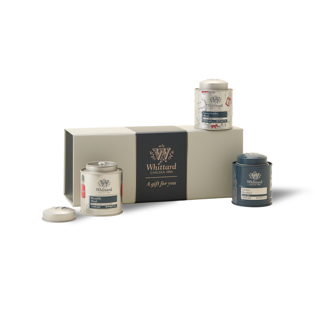 Three collectible mini tea caddies from The British Icons Mini Caddy Gift Box—white, blue, and a white one with animal illustrations—with one lid removed, are arranged beside the rectangular gift box labeled “A gift for you,” all set against a crisp white background.